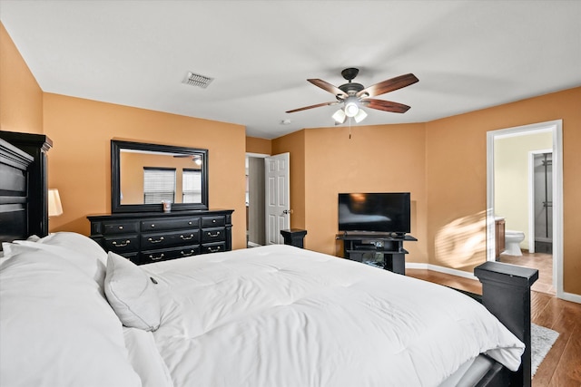 bedroom with ensuite bath, ceiling fan, and hardwood / wood-style floors