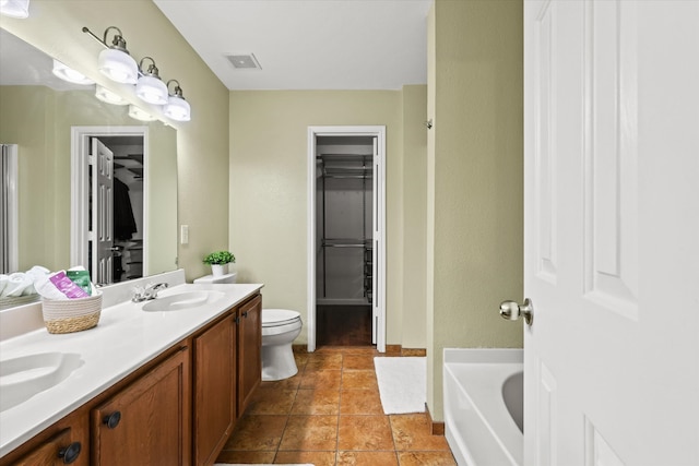 bathroom with vanity, toilet, and a tub