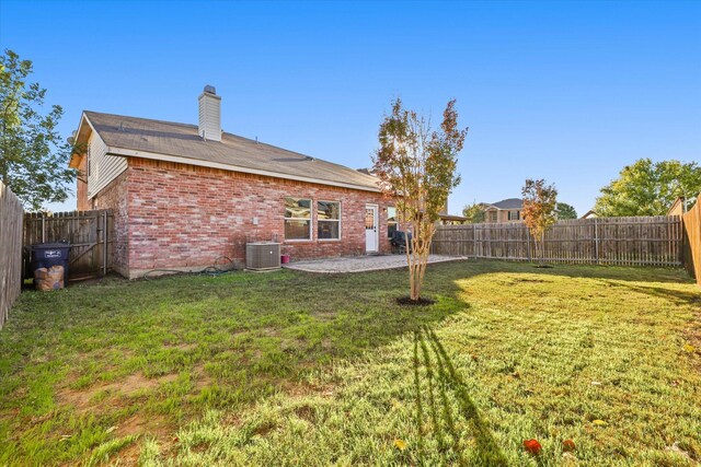 view of yard with central AC and a patio