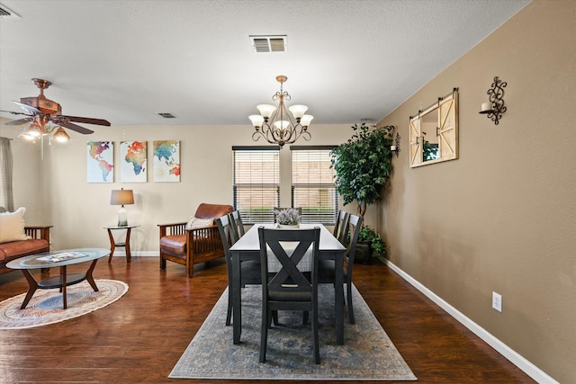 dining space with dark hardwood / wood-style flooring and ceiling fan with notable chandelier