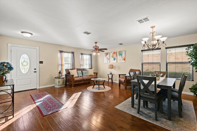 dining area featuring ceiling fan with notable chandelier and dark wood-type flooring