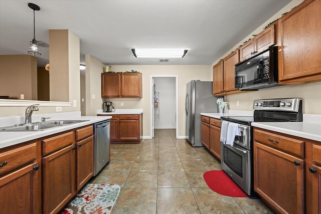 kitchen featuring light tile patterned flooring, appliances with stainless steel finishes, hanging light fixtures, and sink