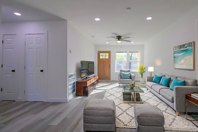 living room featuring ceiling fan and light hardwood / wood-style floors