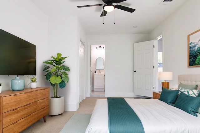 bedroom with ensuite bathroom, sink, ceiling fan, and light colored carpet