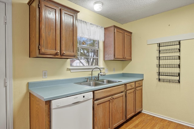 kitchen with light hardwood / wood-style floors, sink, white dishwasher, and a textured ceiling