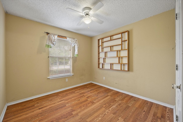 spare room featuring a textured ceiling, hardwood / wood-style flooring, and ceiling fan