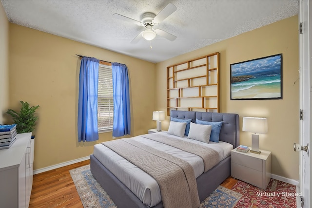 bedroom featuring ceiling fan, a textured ceiling, and wood-type flooring