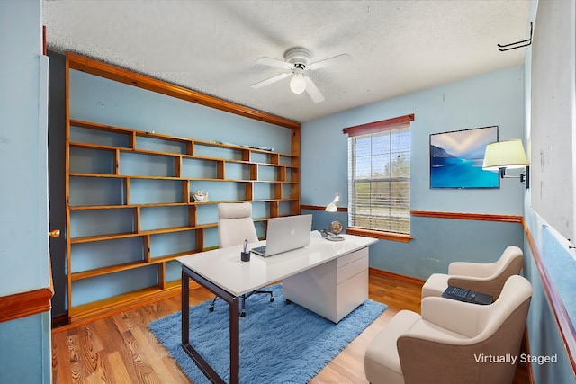 home office featuring ceiling fan, a textured ceiling, and light hardwood / wood-style flooring