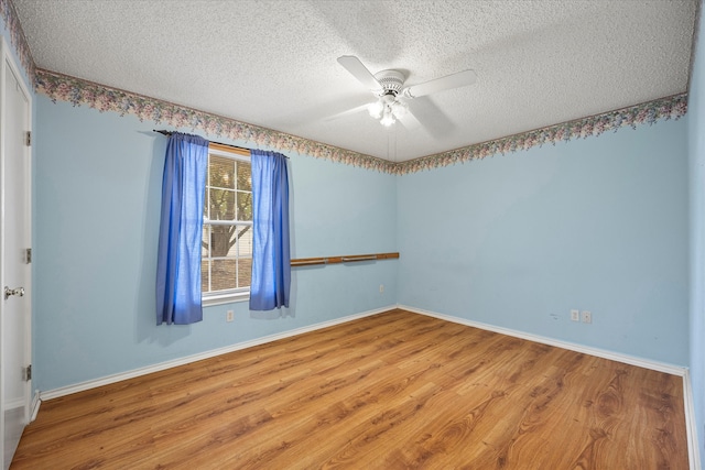 spare room with ceiling fan, wood-type flooring, and a textured ceiling