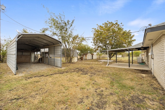 view of yard featuring central AC unit, a carport, and a shed