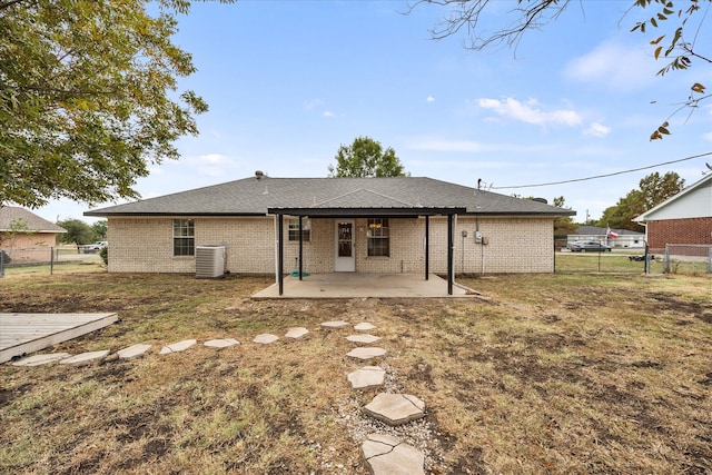 rear view of house featuring a patio, cooling unit, and a lawn