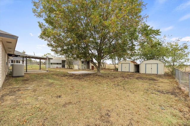 view of yard with central air condition unit, a patio area, and a storage unit