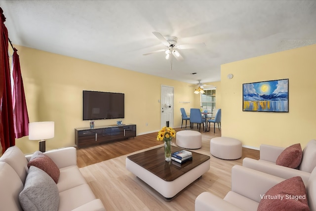 living room featuring light hardwood / wood-style flooring and ceiling fan