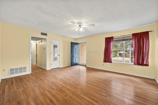 spare room with wood-type flooring, ceiling fan, and a textured ceiling