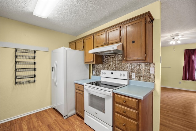 kitchen featuring tasteful backsplash, a textured ceiling, white appliances, ceiling fan, and light hardwood / wood-style flooring