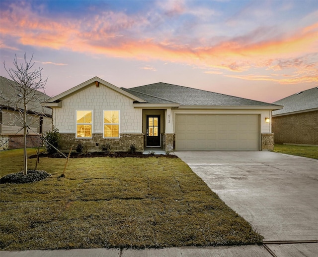 view of front of property with a garage and a lawn