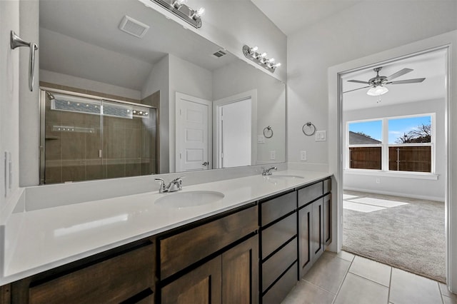 bathroom featuring ceiling fan, vanity, a shower with door, and tile patterned floors