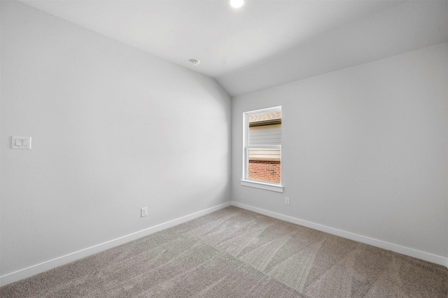 empty room featuring lofted ceiling and carpet flooring