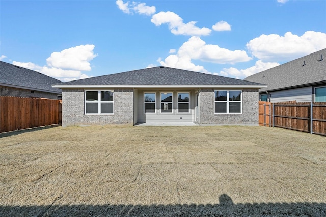 rear view of property featuring a lawn