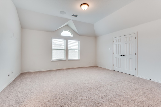 unfurnished room with vaulted ceiling and carpet flooring