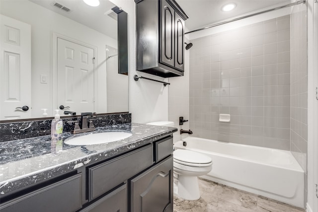 full bathroom with vanity, tiled shower / bath combo, and toilet