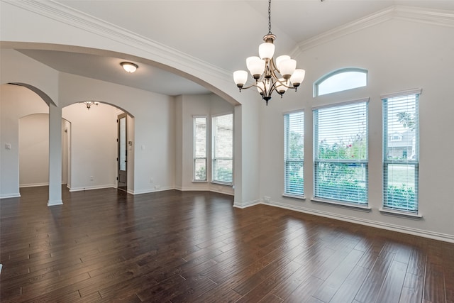 empty room with dark hardwood / wood-style flooring, crown molding, vaulted ceiling, and a chandelier