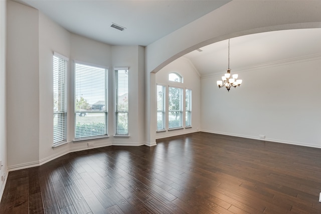 empty room featuring an inviting chandelier, dark hardwood / wood-style flooring, and vaulted ceiling