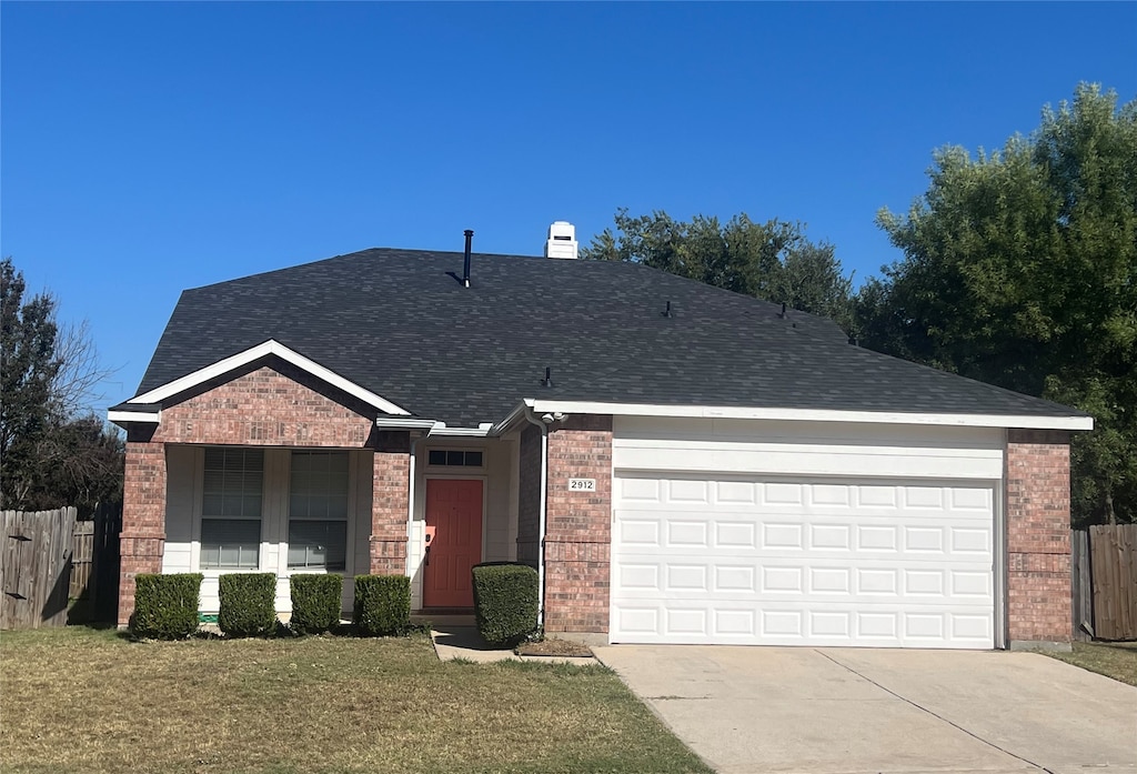 ranch-style home with a garage and a front yard