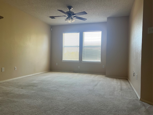 carpeted spare room featuring a textured ceiling and ceiling fan