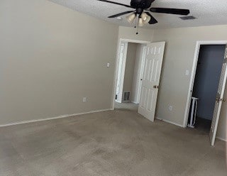 unfurnished bedroom featuring ceiling fan, a textured ceiling, and light colored carpet