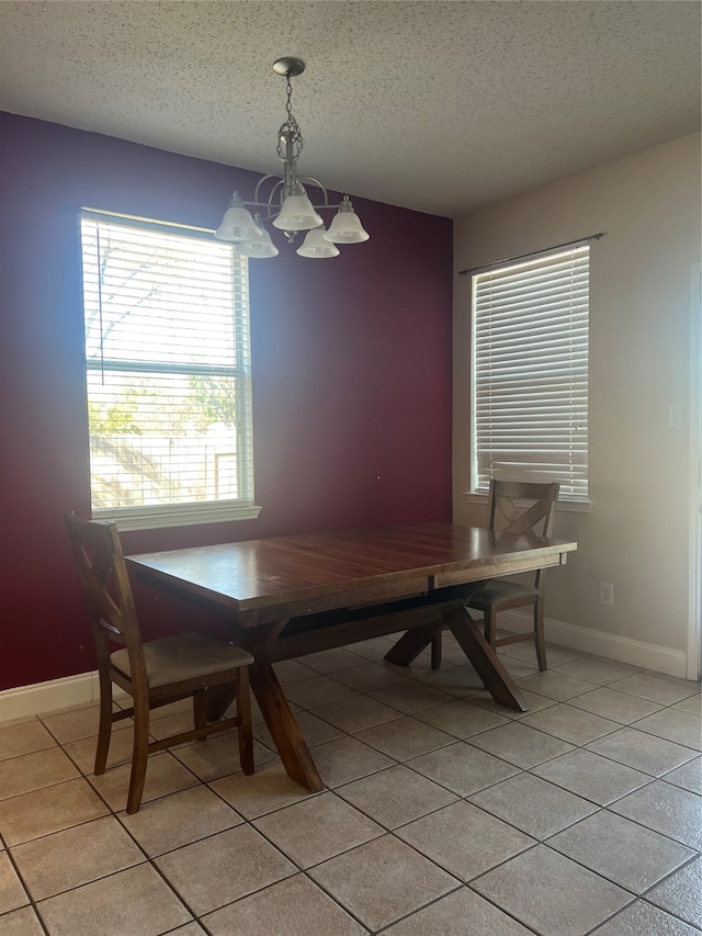 dining room featuring a chandelier, a textured ceiling, and light tile patterned floors