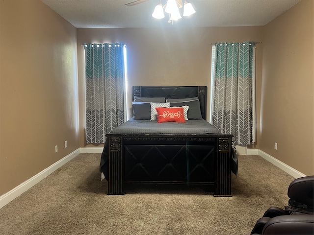 bedroom featuring ceiling fan, a textured ceiling, and carpet