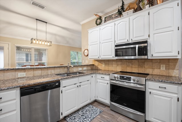 kitchen featuring white cabinetry, kitchen peninsula, stainless steel appliances, and sink