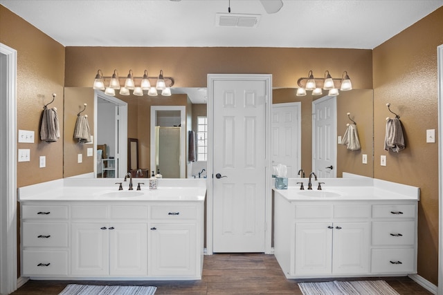 bathroom with wood-type flooring, vanity, and a shower with shower door