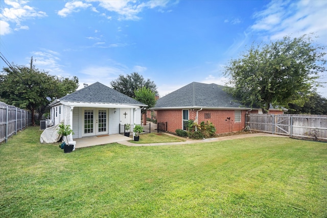 rear view of house with a patio area, a lawn, and french doors