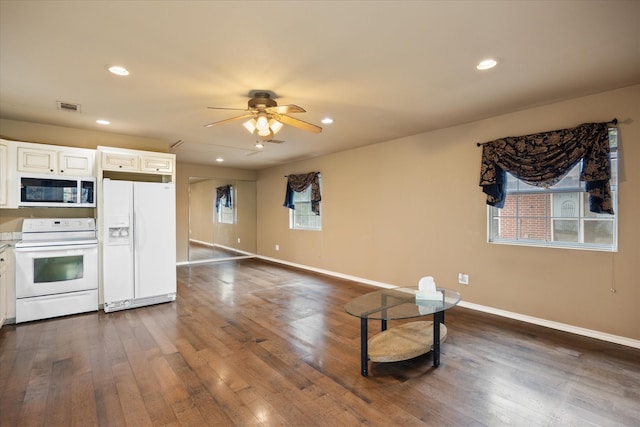 kitchen with white cabinets, dark hardwood / wood-style flooring, ceiling fan, and white appliances