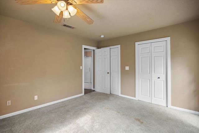 unfurnished bedroom with ceiling fan, multiple closets, and carpet