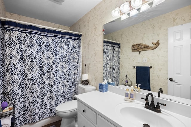 bathroom with toilet, vanity, and curtained shower