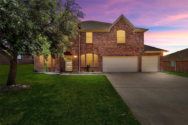 view of front of property with a garage and a yard