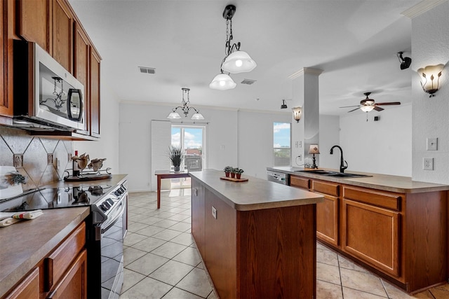 kitchen featuring pendant lighting, a center island, sink, ceiling fan, and stainless steel appliances