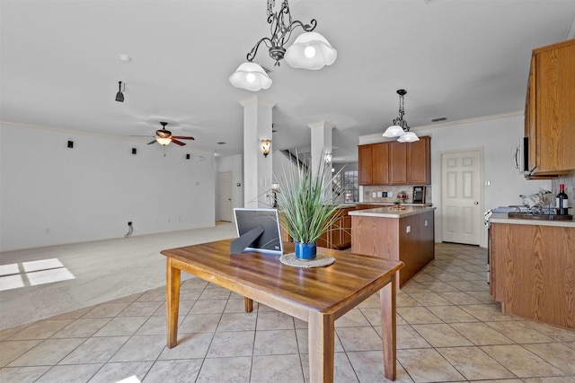 kitchen with light carpet, ornamental molding, ceiling fan, pendant lighting, and a center island