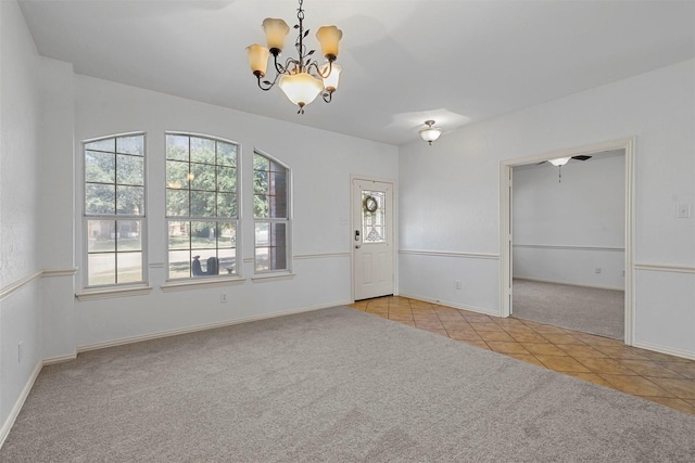 tiled empty room with a notable chandelier