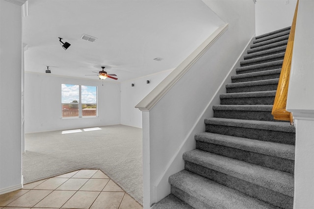 staircase featuring carpet and ceiling fan