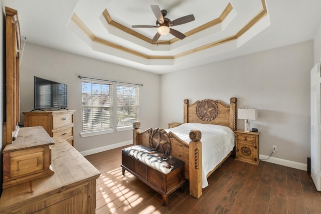 bedroom featuring a raised ceiling, dark hardwood / wood-style floors, and ceiling fan