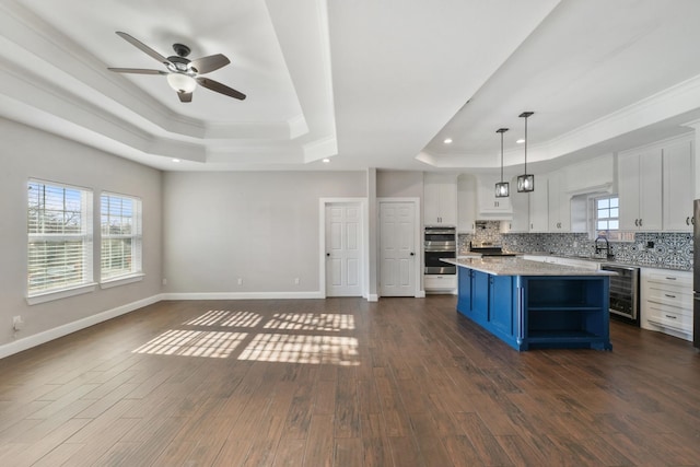 kitchen with white cabinetry, beverage cooler, dark hardwood / wood-style flooring, and a kitchen island