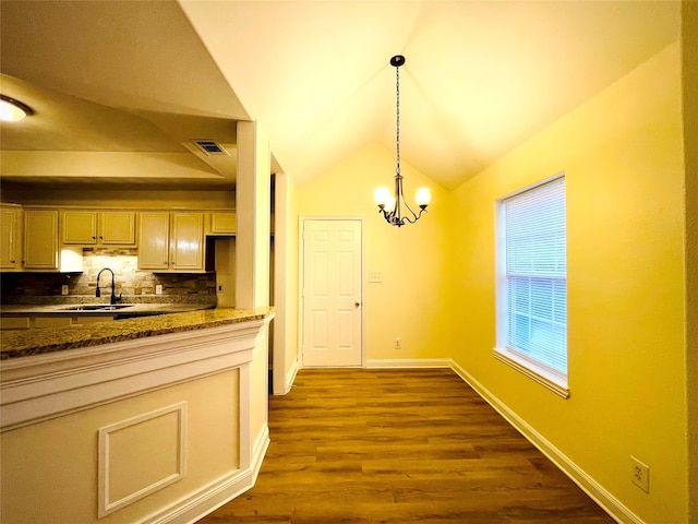 kitchen with decorative backsplash, vaulted ceiling, sink, a notable chandelier, and dark hardwood / wood-style floors