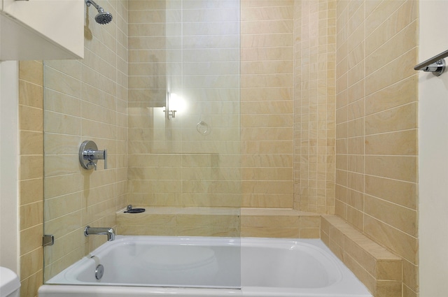 bathroom featuring tiled shower / bath and toilet