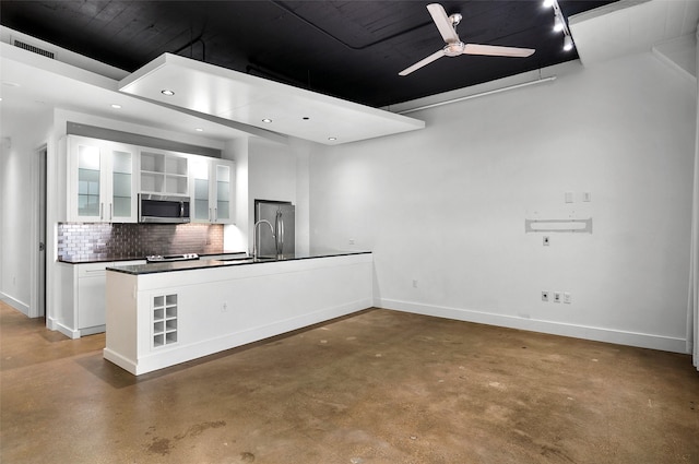 kitchen with white cabinetry, concrete floors, appliances with stainless steel finishes, tasteful backsplash, and ceiling fan