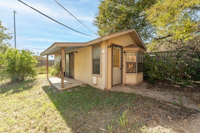 view of property exterior with an outdoor structure and a lawn