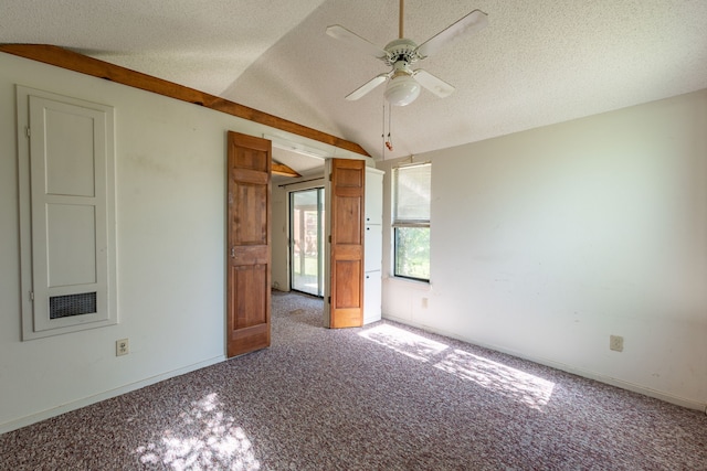 empty room featuring lofted ceiling, ceiling fan, and a textured ceiling